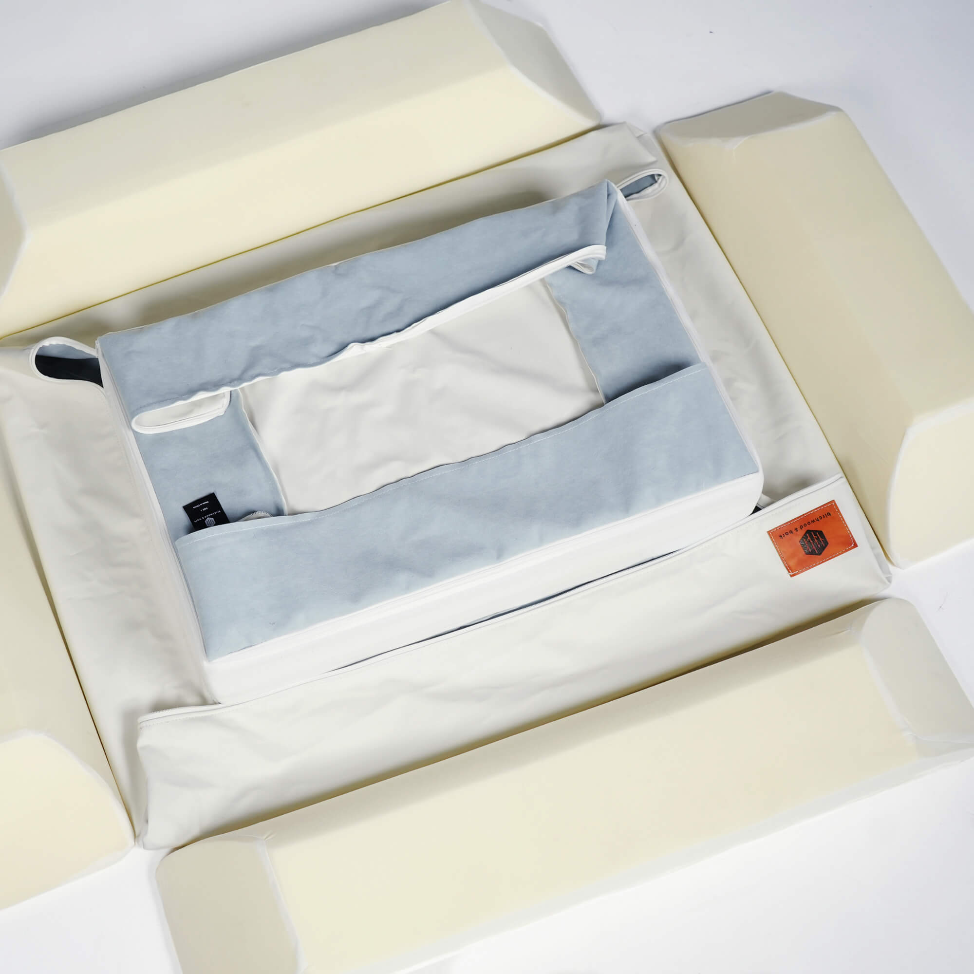 A Birchwood & Bark dog bed being sprayed with a cleaning solution, highlighting its waterproof and easy-to-clean surface.