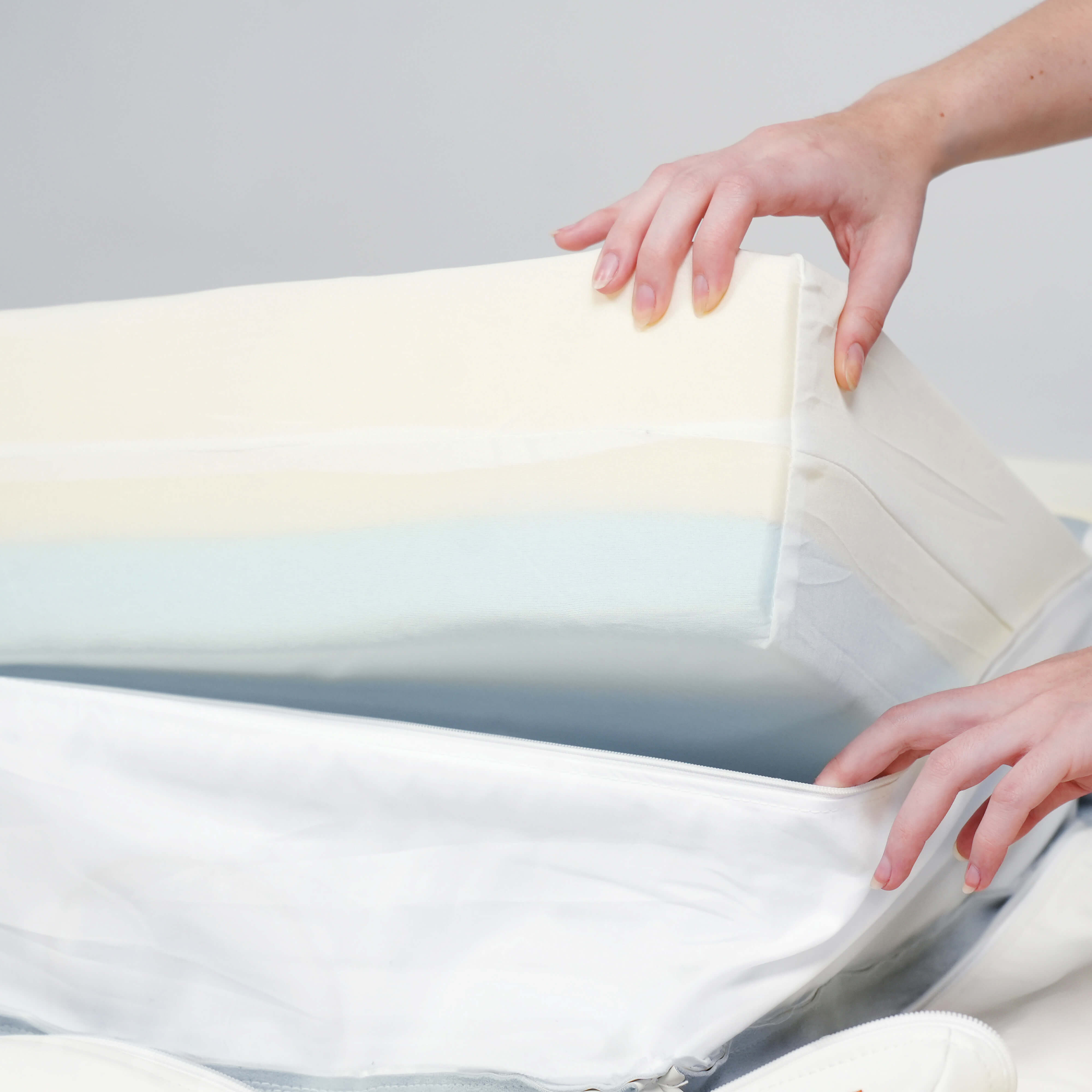 A woman carefully removes a White Eco-Cover from a Birchwood & Bark dog bed.