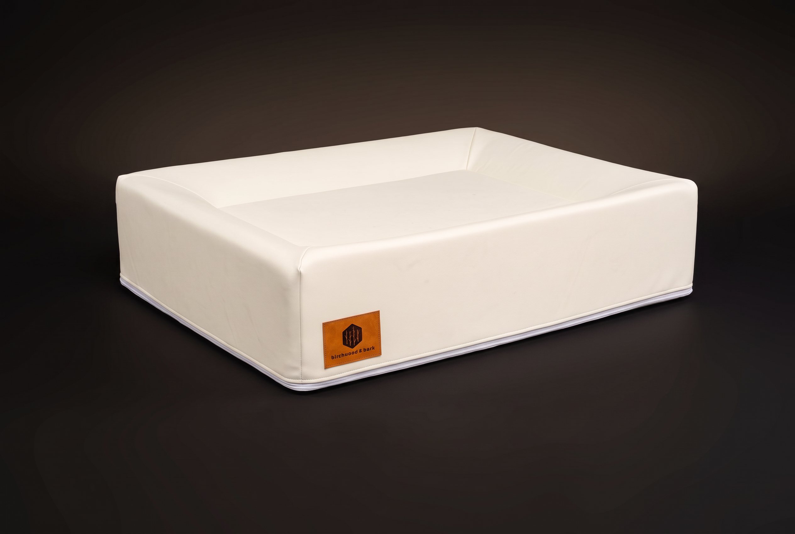 Medium Birchwood & Bark dog bed, cream medical-grade composite leather shell, three-quarter view